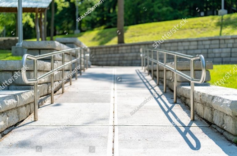 stock-photo-outdoor-exterior-gray-concrete-ramped-sidewalk-with-stainless-steel-railings-2426320529