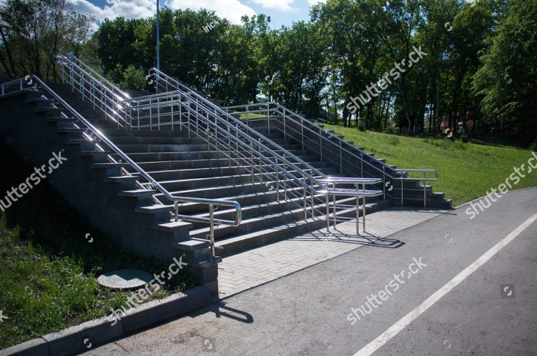 stock-photo-stairs-with-concrete-steps-metal-shiny-railings-in-the-park-in-the-summer-1647252874